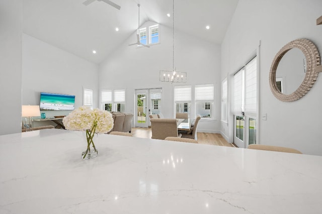 dining space featuring french doors, high vaulted ceiling, a chandelier, light wood-style floors, and recessed lighting