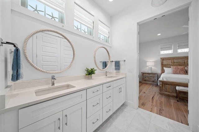 full bathroom with recessed lighting, double vanity, baseboards, ensuite bath, and marble look tiles