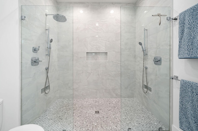 bathroom featuring toilet and a stall shower
