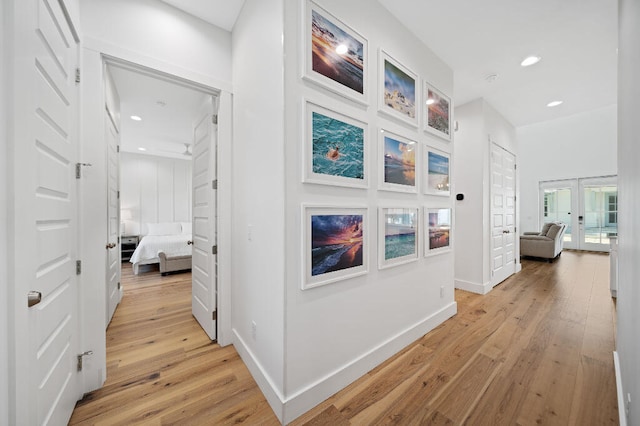 hall with light wood finished floors, french doors, baseboards, and recessed lighting