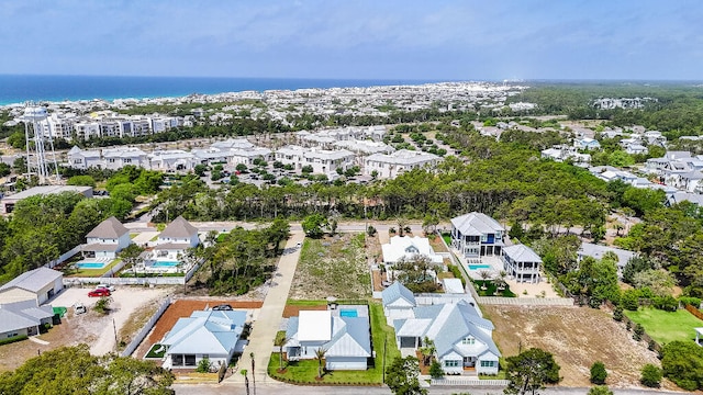 aerial perspective of suburban area with a pool area and a large body of water