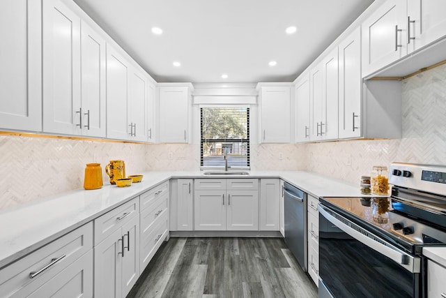 kitchen featuring sink, white cabinetry, appliances with stainless steel finishes, dark hardwood / wood-style flooring, and decorative backsplash