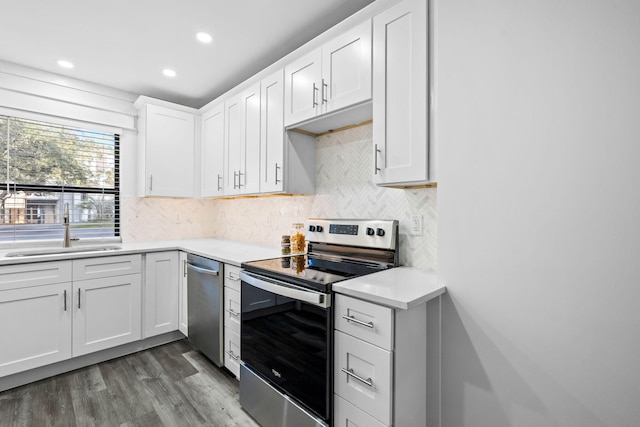 kitchen with white cabinetry, stainless steel appliances, sink, and decorative backsplash