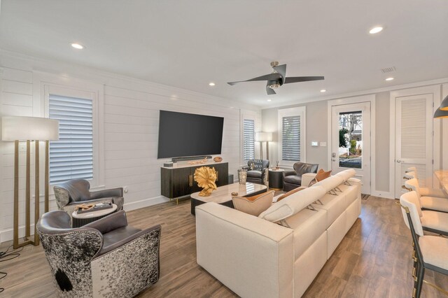 living room featuring light hardwood / wood-style floors, ceiling fan, and ornamental molding