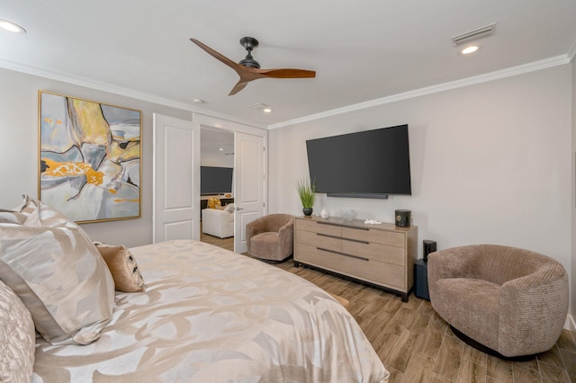 bedroom featuring ceiling fan, crown molding, and light hardwood / wood-style flooring