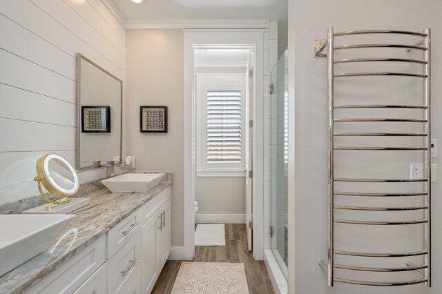 bathroom featuring walk in shower, ornamental molding, vanity, hardwood / wood-style floors, and toilet