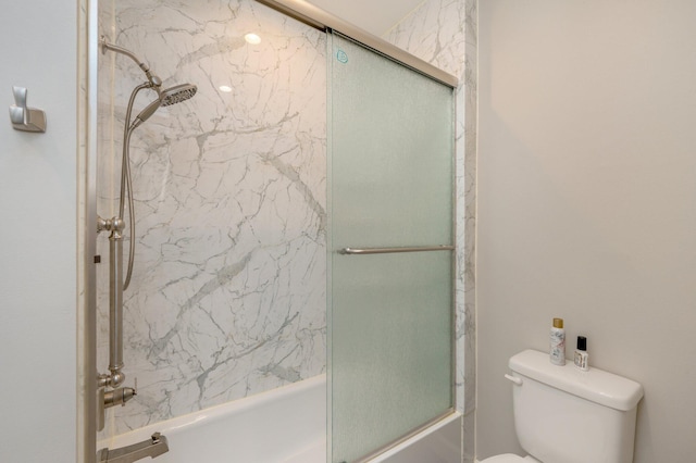 bathroom featuring shower / bath combination with glass door and toilet