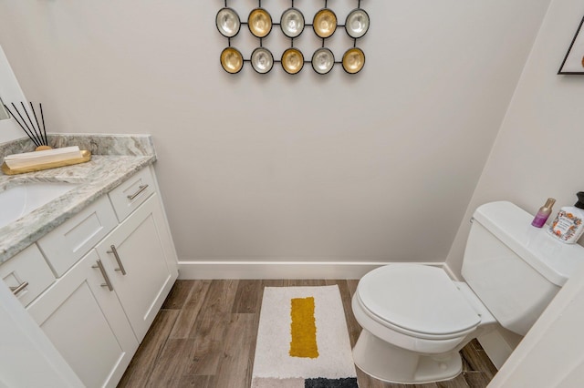 bathroom with wood-type flooring, vanity, and toilet