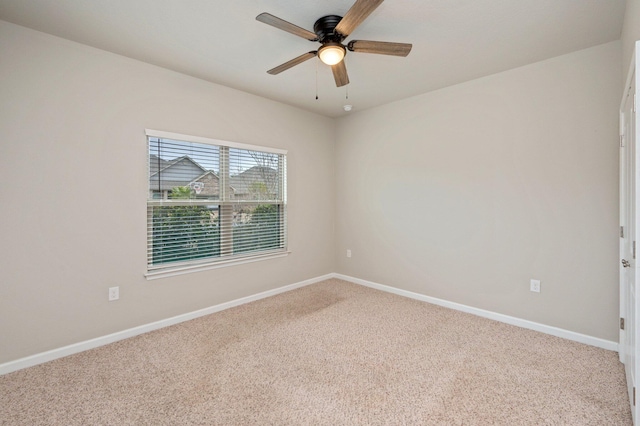 carpeted spare room with ceiling fan