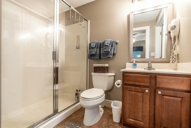 bathroom with a shower with shower door, vanity, tile patterned flooring, and toilet