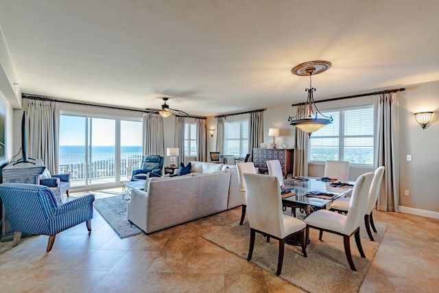 dining area featuring ceiling fan and a water view