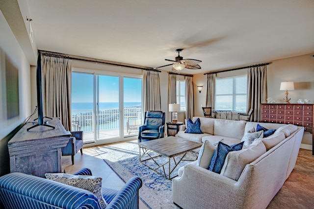 tiled living room featuring ceiling fan and a water view