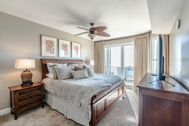 carpeted bedroom featuring ceiling fan, access to exterior, and a textured ceiling