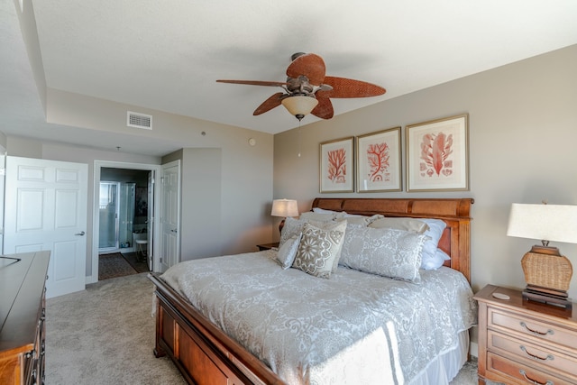 bedroom featuring ceiling fan, connected bathroom, and light carpet