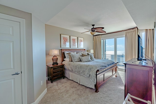 bedroom featuring ceiling fan, access to exterior, and light colored carpet