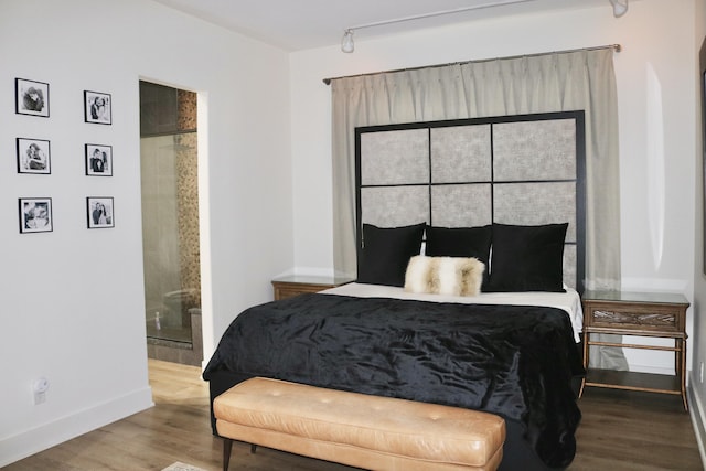 bedroom with hardwood / wood-style flooring and ensuite bath