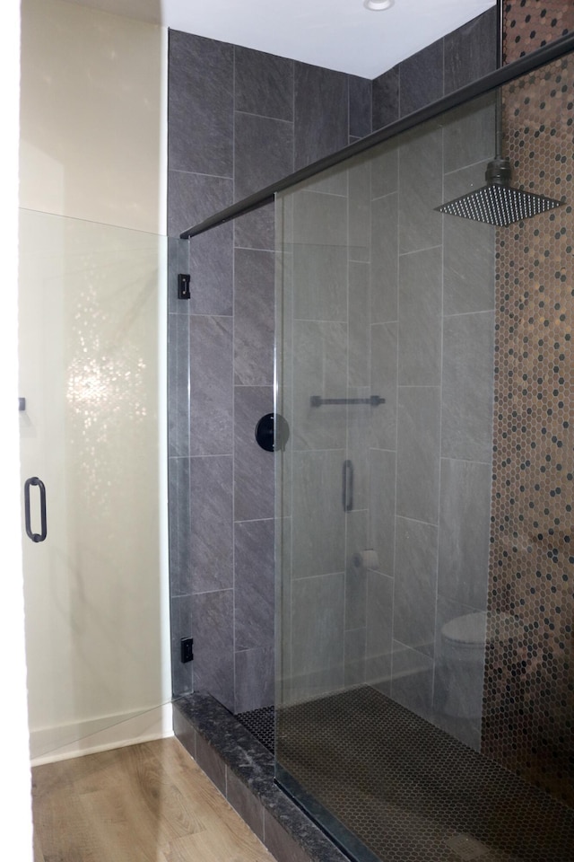 bathroom featuring hardwood / wood-style floors and an enclosed shower