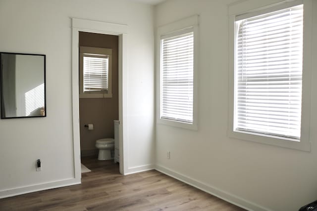 unfurnished bedroom with hardwood / wood-style floors and ensuite bath