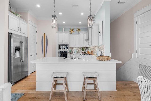 kitchen with stainless steel appliances, hanging light fixtures, and a breakfast bar area