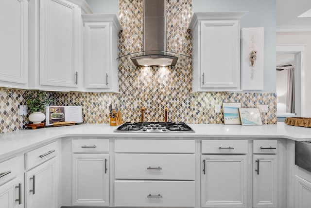 kitchen with white cabinets, tasteful backsplash, stainless steel gas cooktop, and wall chimney range hood