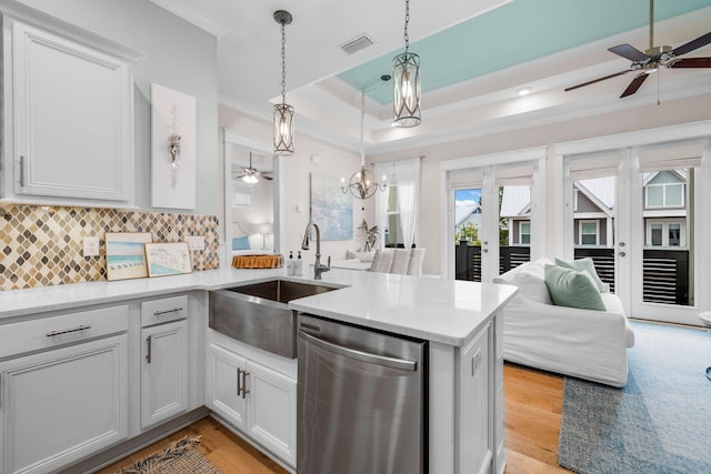 kitchen with sink, stainless steel dishwasher, backsplash, kitchen peninsula, and decorative light fixtures