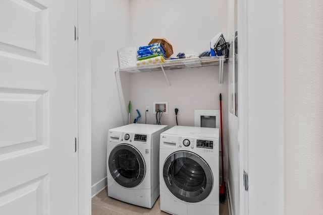 laundry room with washer and dryer and light tile patterned flooring