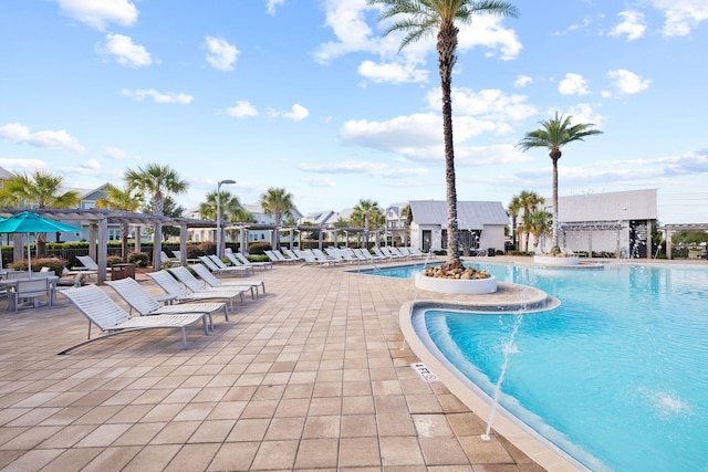 view of pool featuring pool water feature, a patio, and a pergola