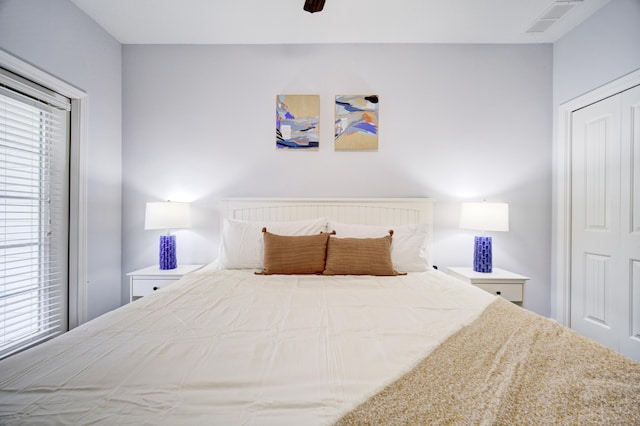 bedroom with multiple windows, ceiling fan, and a closet