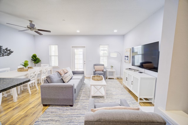 living room featuring ceiling fan, a healthy amount of sunlight, and light hardwood / wood-style floors