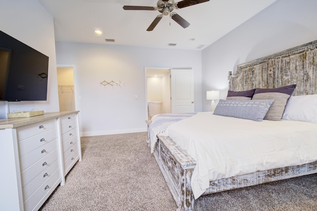 bedroom featuring light carpet, a closet, a spacious closet, and ceiling fan