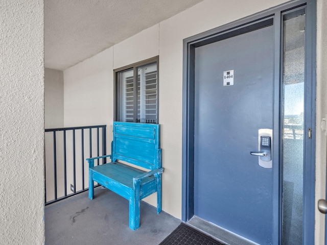 doorway to property featuring a balcony and stucco siding