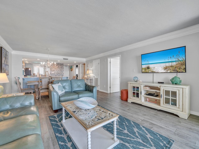 living room featuring a chandelier, crown molding, and wood finished floors