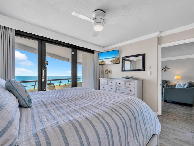 bedroom with crown molding, light wood finished floors, a ceiling fan, a textured ceiling, and access to outside