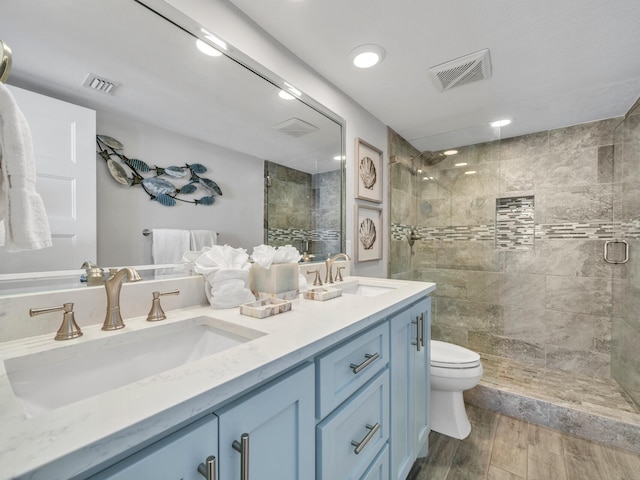 full bathroom featuring a tile shower, a sink, and visible vents