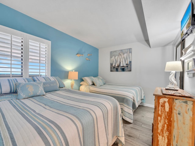 bedroom featuring baseboards and wood finished floors