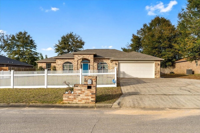 ranch-style house featuring a garage and central AC