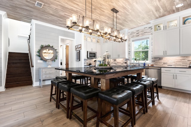 dining room with an inviting chandelier, wood ceiling, stairs, and visible vents