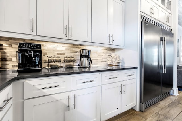 11 Wadleigh Way, Miramar Beach, FL 32550 - kitchen featuring decorative backsplash, dark countertops, white cabinets, and built in refrigerator
