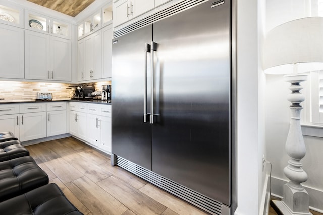 11 Wadleigh Way, Miramar Beach, FL 32550 - kitchen featuring built in fridge, white cabinetry, light wood-style flooring, and tasteful backsplash