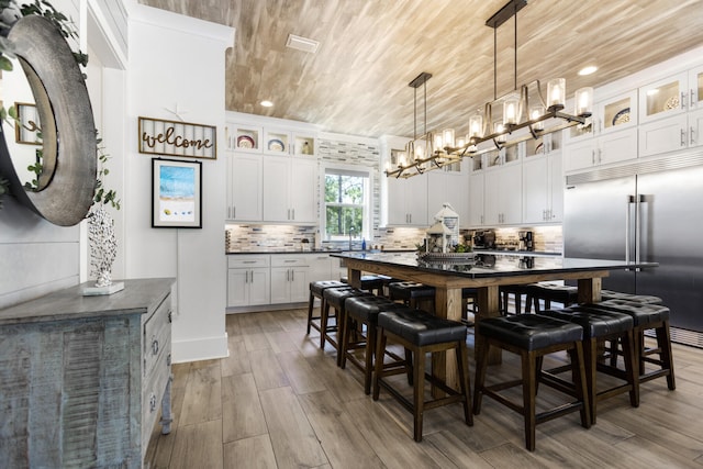11 Wadleigh Way, Miramar Beach, FL 32550 - kitchen with white cabinets, wood ceiling, stainless steel built in refrigerator, and decorative backsplash