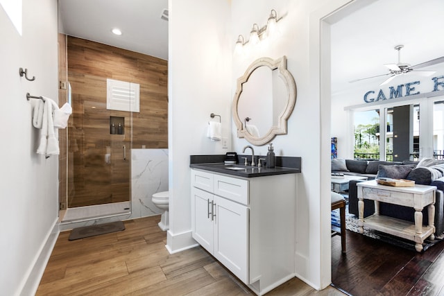 11 Wadleigh Way, Miramar Beach, FL 32550 - bathroom featuring ceiling fan, toilet, wood finished floors, a stall shower, and ensuite bath