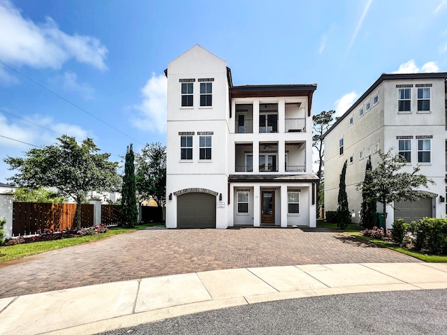 11 Wadleigh Way, Miramar Beach, FL 32550 - view of front facade with an attached garage, a balcony, fence, decorative driveway, and stucco siding