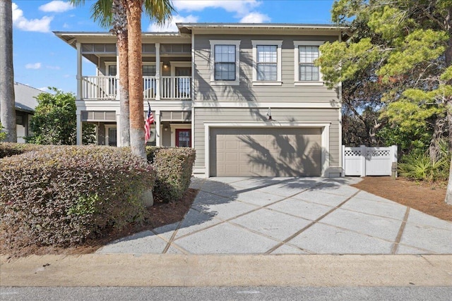 view of front of house with driveway, an attached garage, and fence