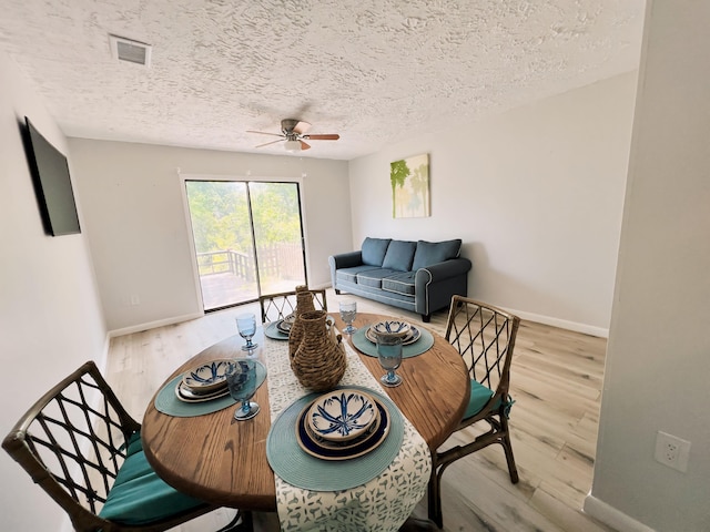 dining area with hardwood / wood-style floors, a textured ceiling, and ceiling fan