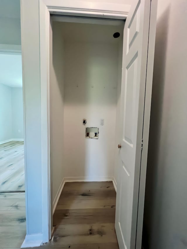 washroom featuring electric dryer hookup, hookup for a washing machine, and light hardwood / wood-style flooring