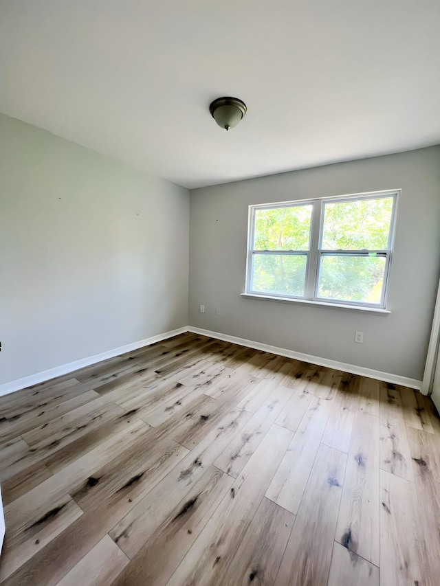 empty room with light hardwood / wood-style flooring