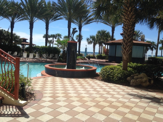 view of pool featuring pool water feature, a hot tub, and a patio