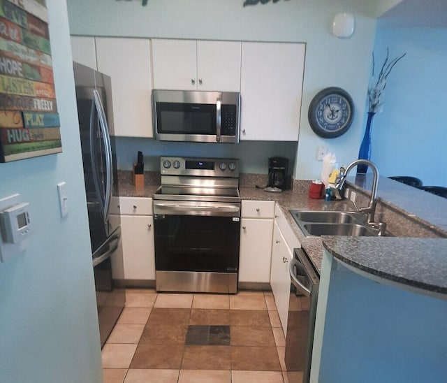 kitchen with sink, white cabinetry, light tile patterned floors, and appliances with stainless steel finishes