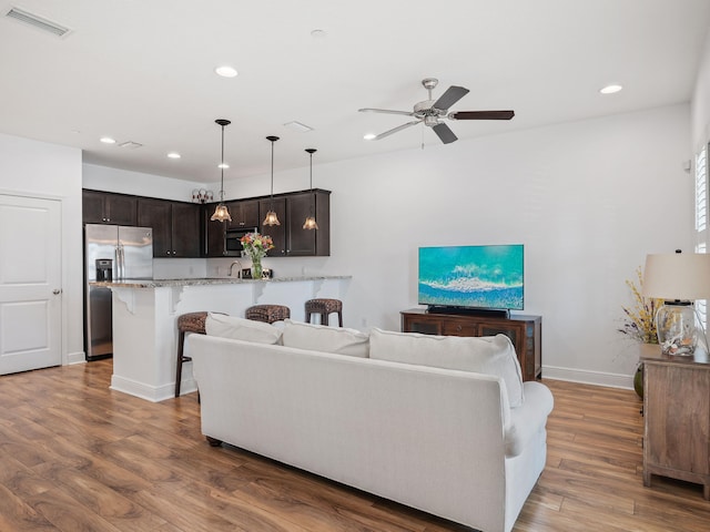 living room featuring hardwood / wood-style flooring and ceiling fan