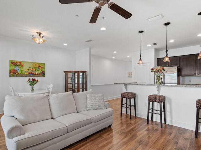 living room with wood-type flooring and ceiling fan